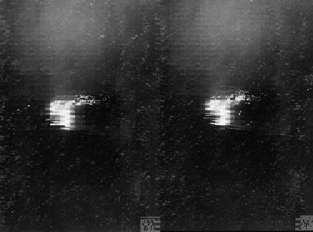 Muzzle flashes and blasts from British artillery highlighted against a dark night sky at Lake Doiran.