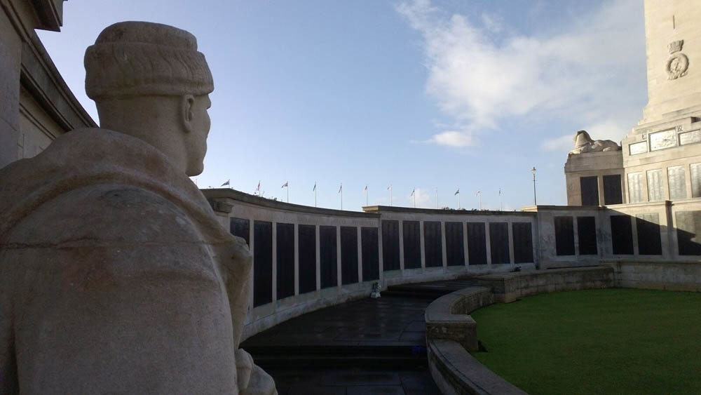 Sculpture of a sailor looks over the name panels at Plymouth Naval Memorial.