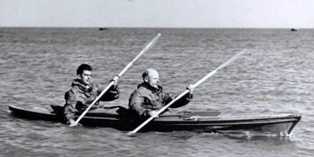 Blondie Hasler and a Royal Marine commando kayaking on a calm sea.