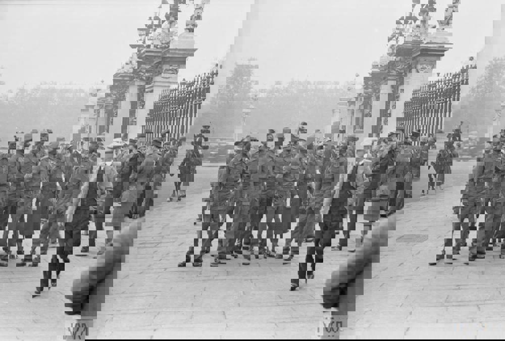 A group of black Caribbean servicemen of the British Army mixing with crowds outside the gates of Buckingham Palace.