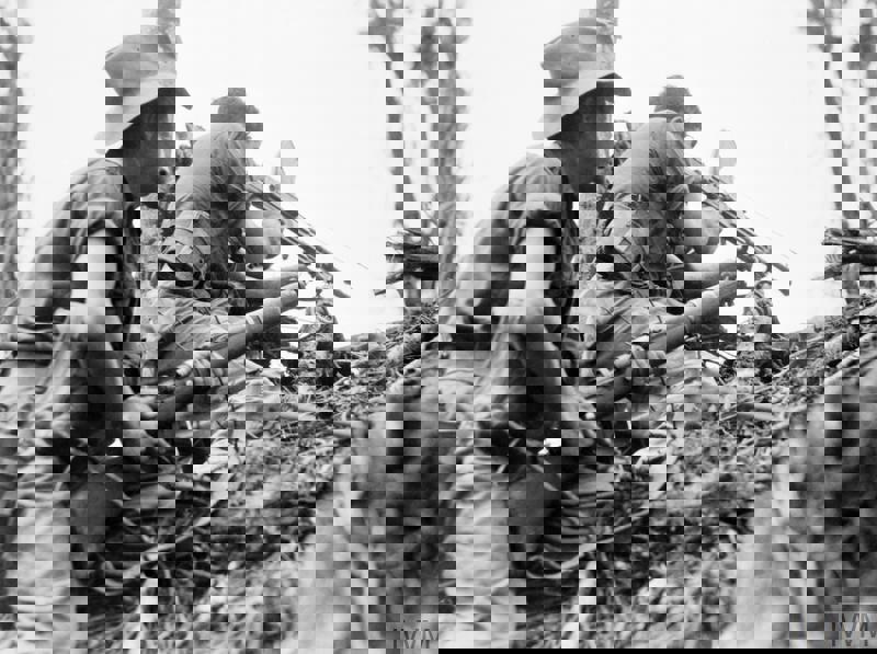 AUstralian infantry in Surge Hats and short fatigues firing at an unseen enemy on Papua New Guinea during the Second World War/