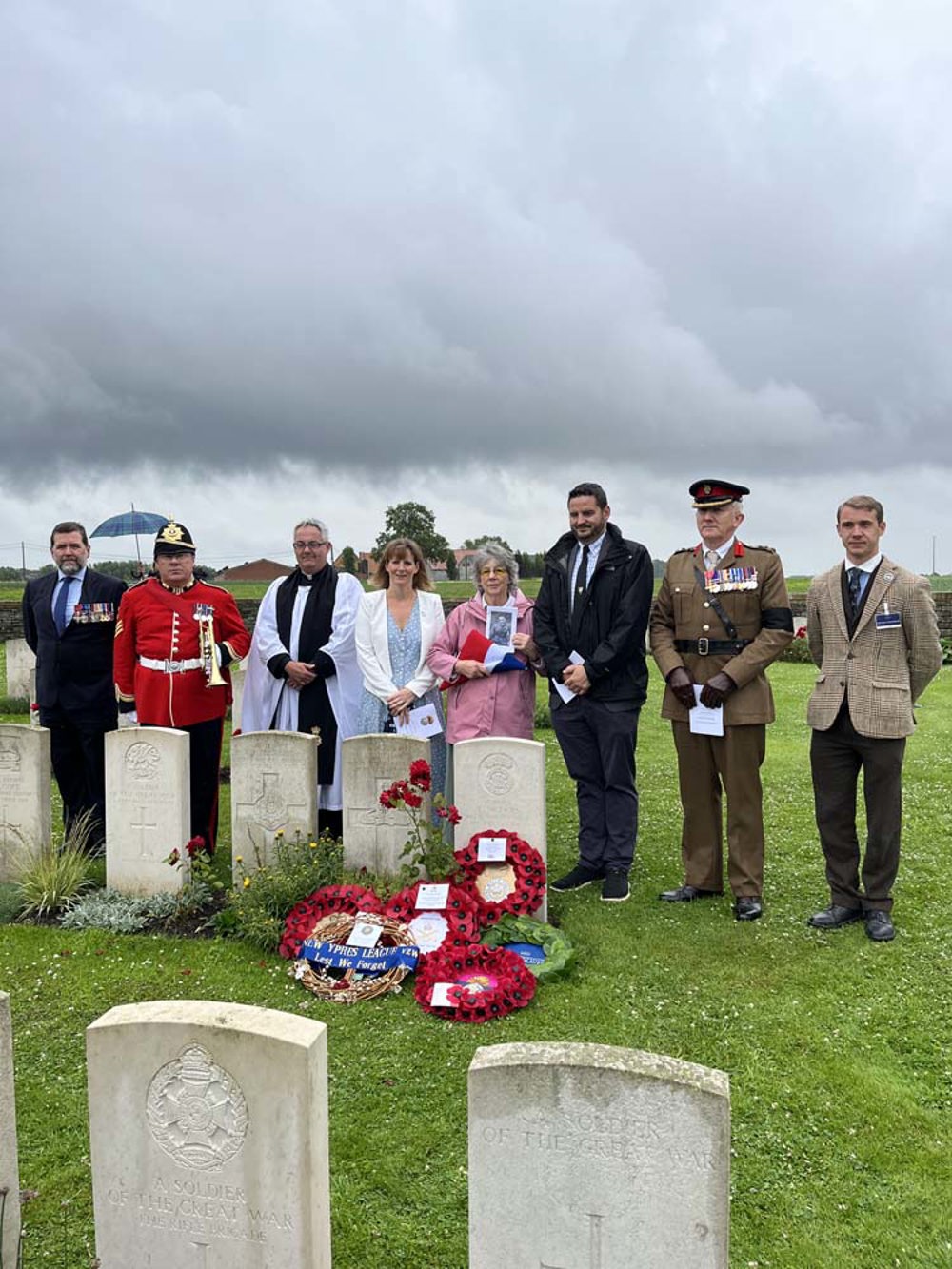 The family of Captain Nichols stand with the military party following the service of his reburial.