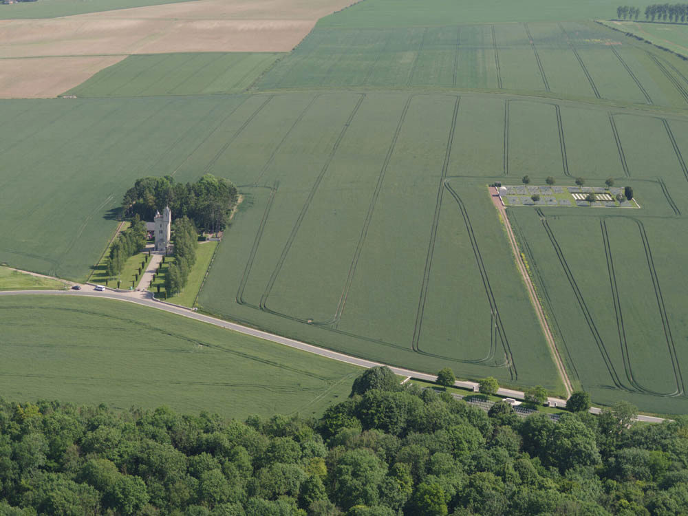 An aerial shot of farmers fields with Ulster Memorial Tower in the bottom left and Mill Road Cemetery to the right.