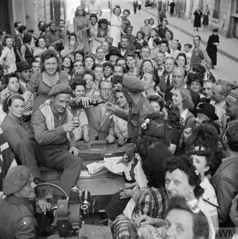 British troops share a drink with Parisians after the city was liberated during World War Two.