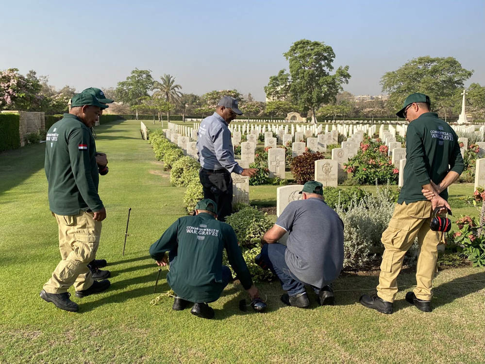 A group of CWGC workers inspect a headstone at Alexandria (Hadra) War Memorial Cemetery.