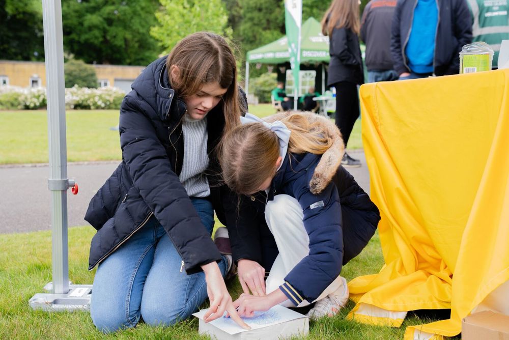 Mother and daugfhter engaging in rubbings of a CWGC headstone at the Runnymede Memorial.