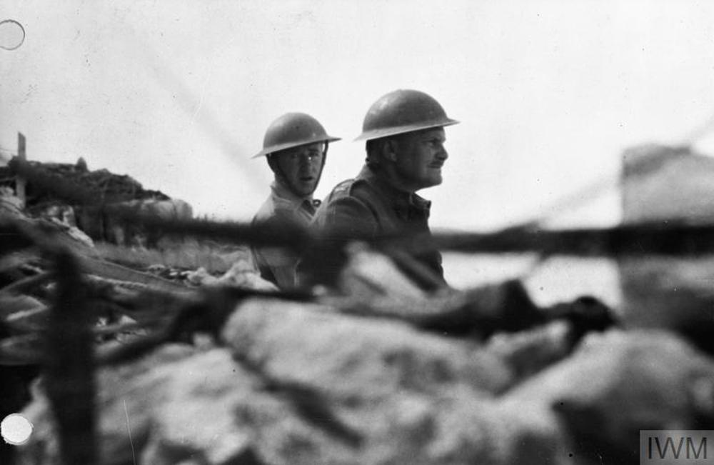Lieutenant General Bernard Freyberg VC, commanding officer of the British forces on Crete, with his Aide-de-camp, Captain Jack Griffiths watch the attack on Maleme airfield from outside the wall at CREFORCE headquarters in the quarry above Canea, 20 May 1941.