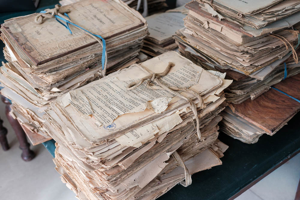 Bundles of old yellowed documents tied with twine.