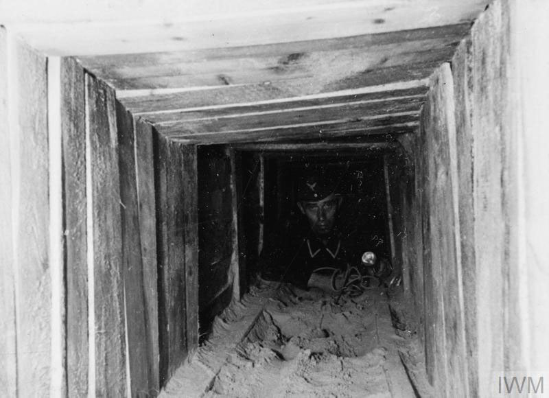 A German soldier at the end of 'Harry' tunnel at Stalag Luft III.