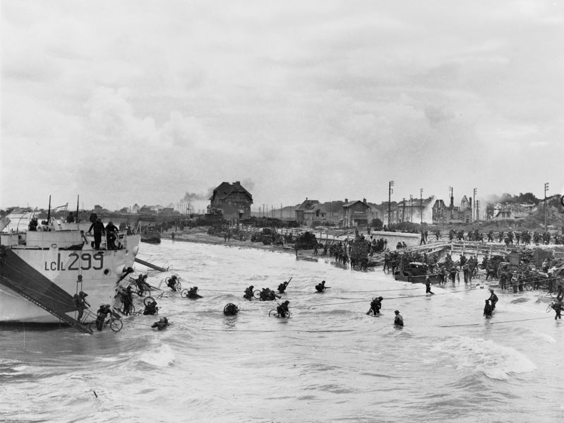 Canadian soldiers wading through the low sea toward Sword Beach.