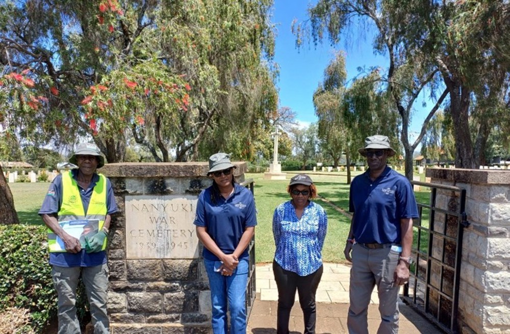 Team of workers posing at the entryway of Nanyuki War Cemetery, Kenya