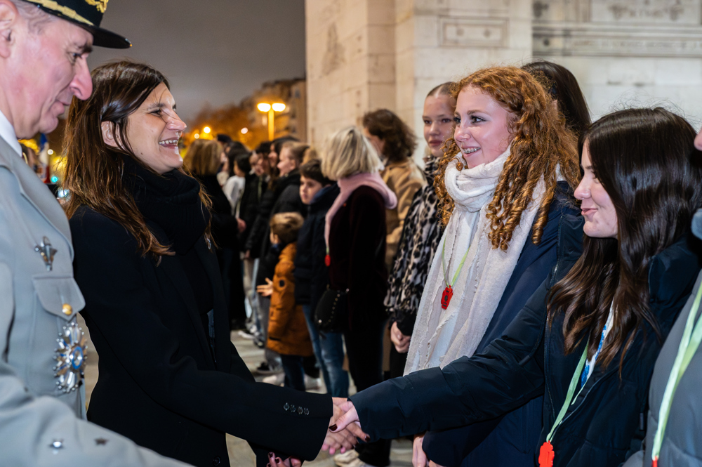 Redheaded teenager shakes hands with a French female politician.