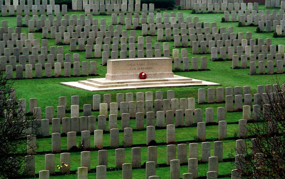 Stone of Remembrance set amidst rows of headstones at Flat Iron Copse Cemetery