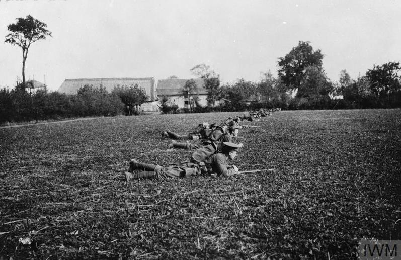 A line of BEF soldiers of the Scots Guards lies in a field ahead of a recon action at Ypres, October 1914.