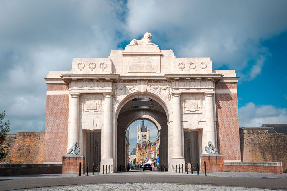 View of the Menin Gate facing towards the town square. The cloth hall spire and row of houses is visible through the gate's central arch.
