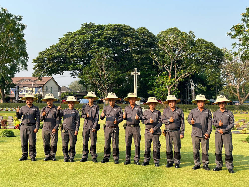 Gardeners at CWGC's Kanchanaburi War Cemetery giving thumbs up for the camera.