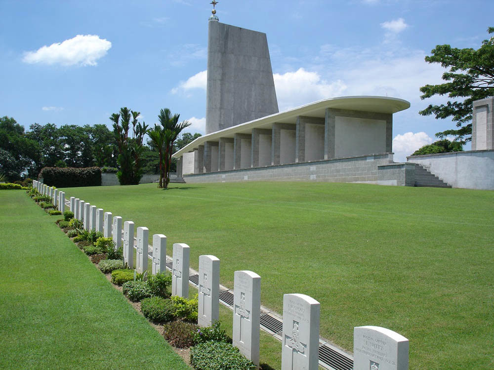 The Singapore Memorial overlooking a row of CWGC headstones at Kranji War Memorial