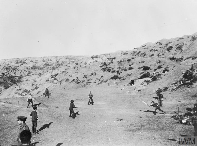 Australian soldiers playing an improvised game of cricket amidst the sandy scrub and dunes at Gallipoli.