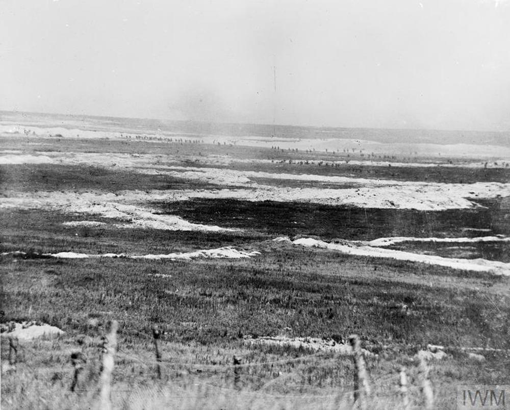 View of a Somme battlefield on the First Day of the Somme showing trenches cut into the chalky soil. Small black dots along the horizon are actually British infantrymen advancing.