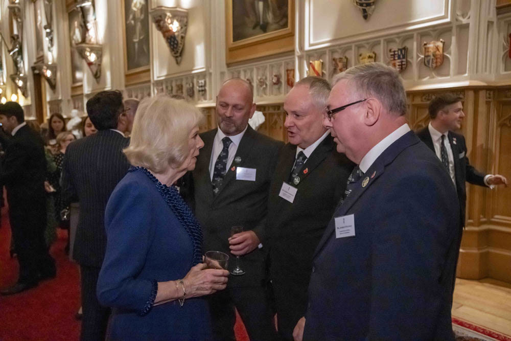 Queen Camilla talks to dignitaries at an event.