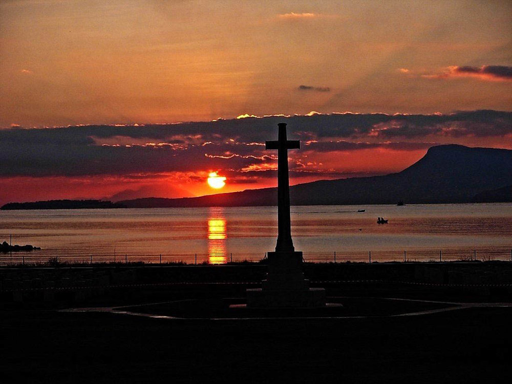 The sunsets over the Agean, framing the cross of sacrifice at Suda Bay War cemetery.