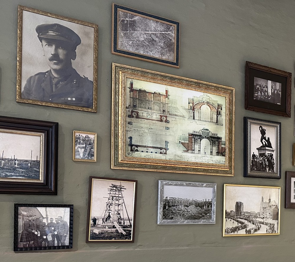 Various pictures of CWGC memorial blueprints, First World War soldiers, crowd shots, and aerial photography displayed on the wall of the Ypres Visitor Centre.