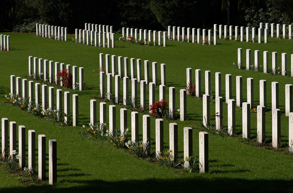 Rows of CWGC headstones at Brookwood Military Cemetery set on a green lawn.