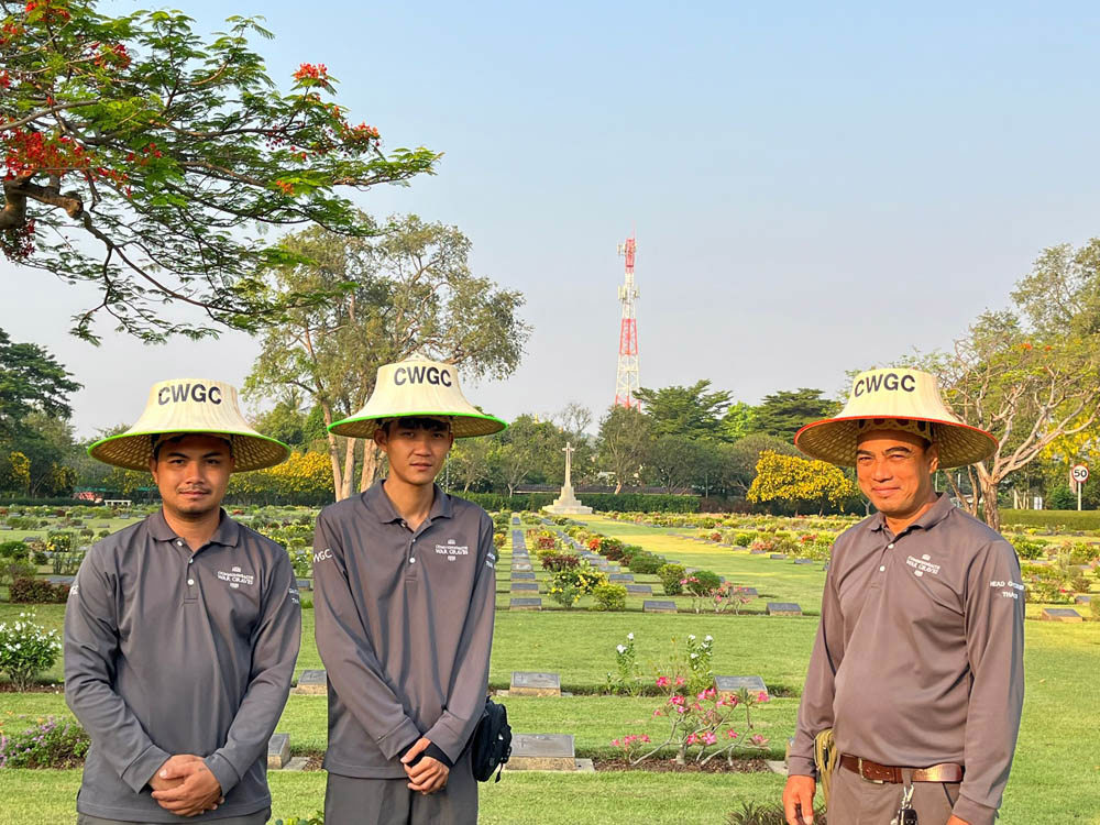 Gardeners at Chungkai War Cemetery pose in CWGC-branded straw hats,