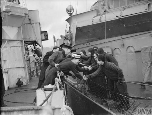 British and United States sailors greet each other from their destroyers which are secured alongside when the first United States warships escorting a convoy across the Atlantic arrived at Londonderry, January-February 1942.