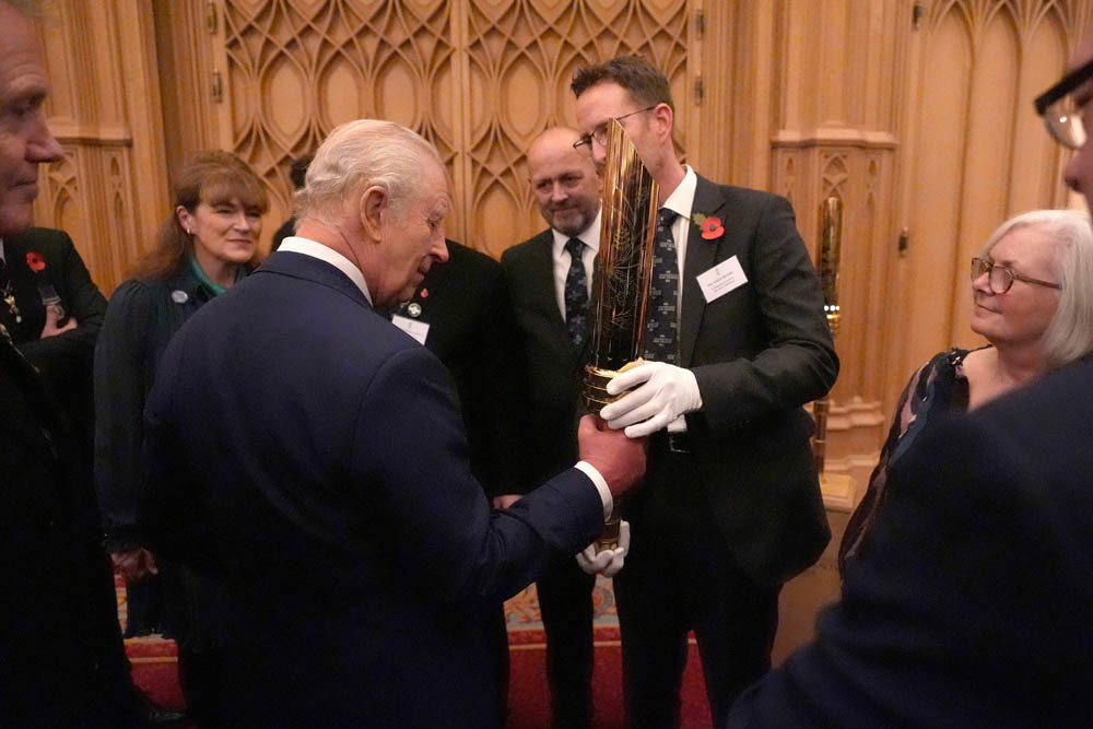 King Charles III handles the CWGC Torch for Peace.