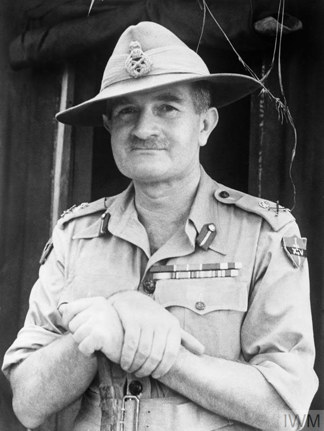 General William Slim with a rifle slung over his shoulder in peaked cap.