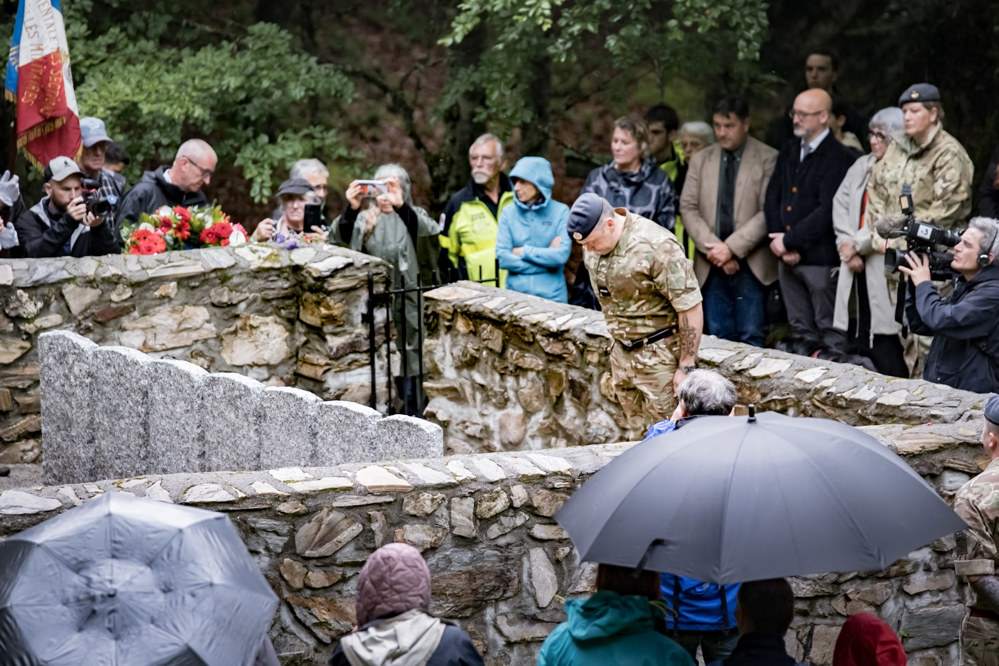 A soldier bows his head in a ceremony rededicating war graves.