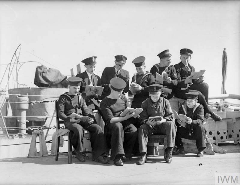 Young sailors continue their studies on active service. April 1944, on board HMS Guillemot, at Harwich. Three RNVR officers of the Guillemot who were all students before they joined the navy, continue their studies in the ship, and have started a play reading circle for the ship's company.