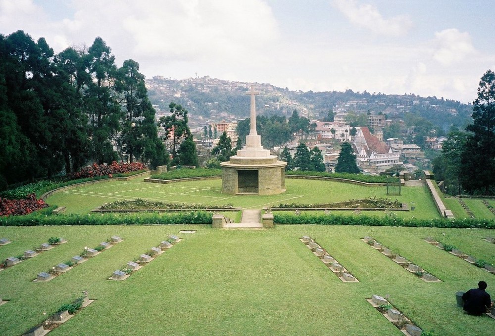 Cross of Sacrifice at KOhima War Cemetery with the city of Kohima visible behind the cemetery.