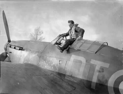 Howard Blatchford pulls himself out of the cockpit of a Hawker Hurricane fighter plane.
